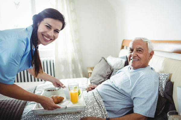 elder man getting a meal from nurse